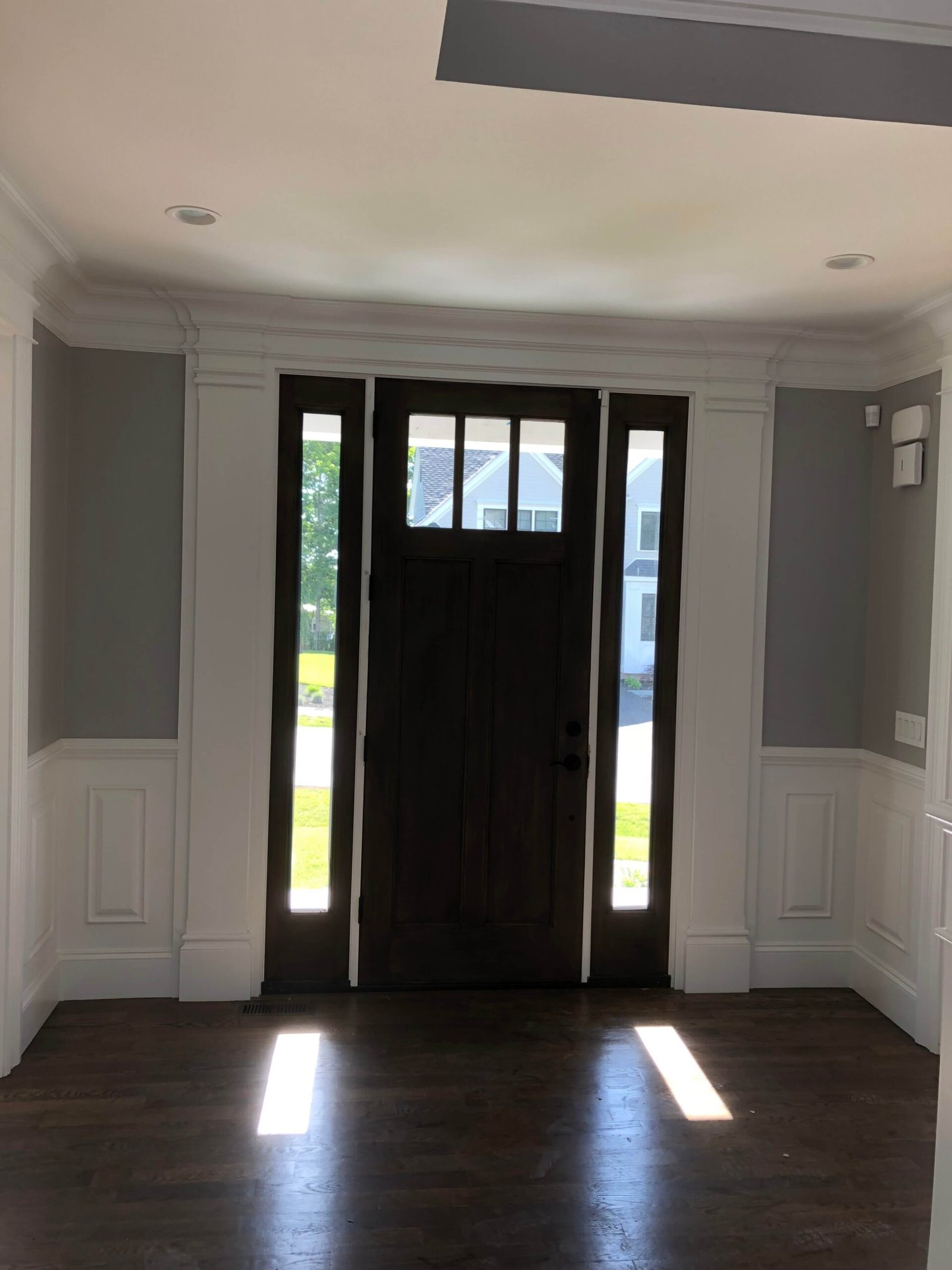 Custom front door surround with wainscoting flanking